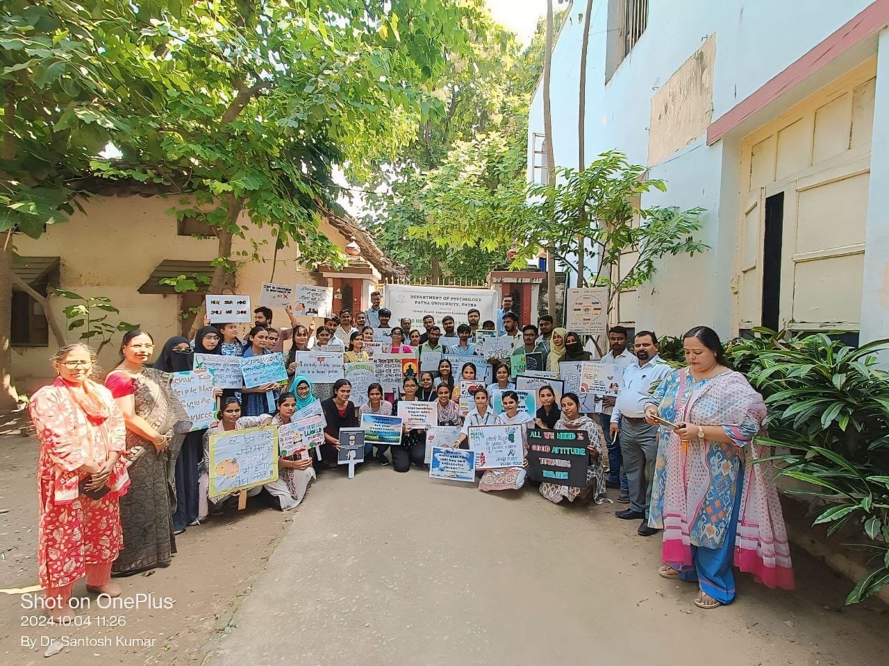Group of students and faculty members participating in a mental health awareness rally at Patna University Psychology Department, holding placards promoting mental health.